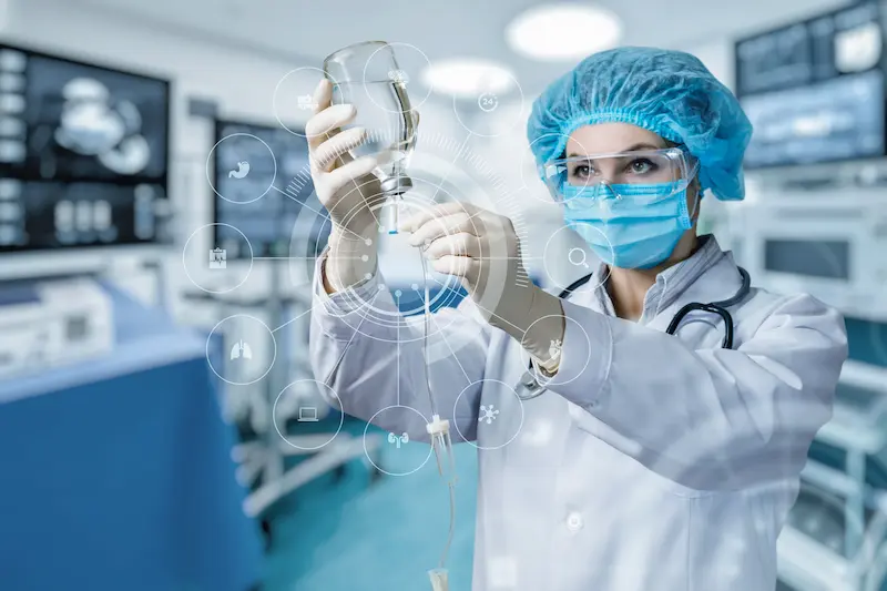 Порт для химиотерапии: врач в защитной экипировке готовит капельницу для инфузии.